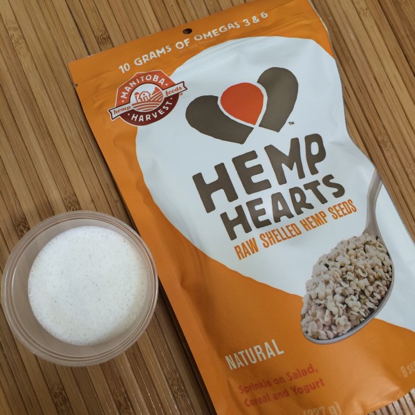 Manitoba Hemp Hearts next to a small cup of freshly blended hemp milk.